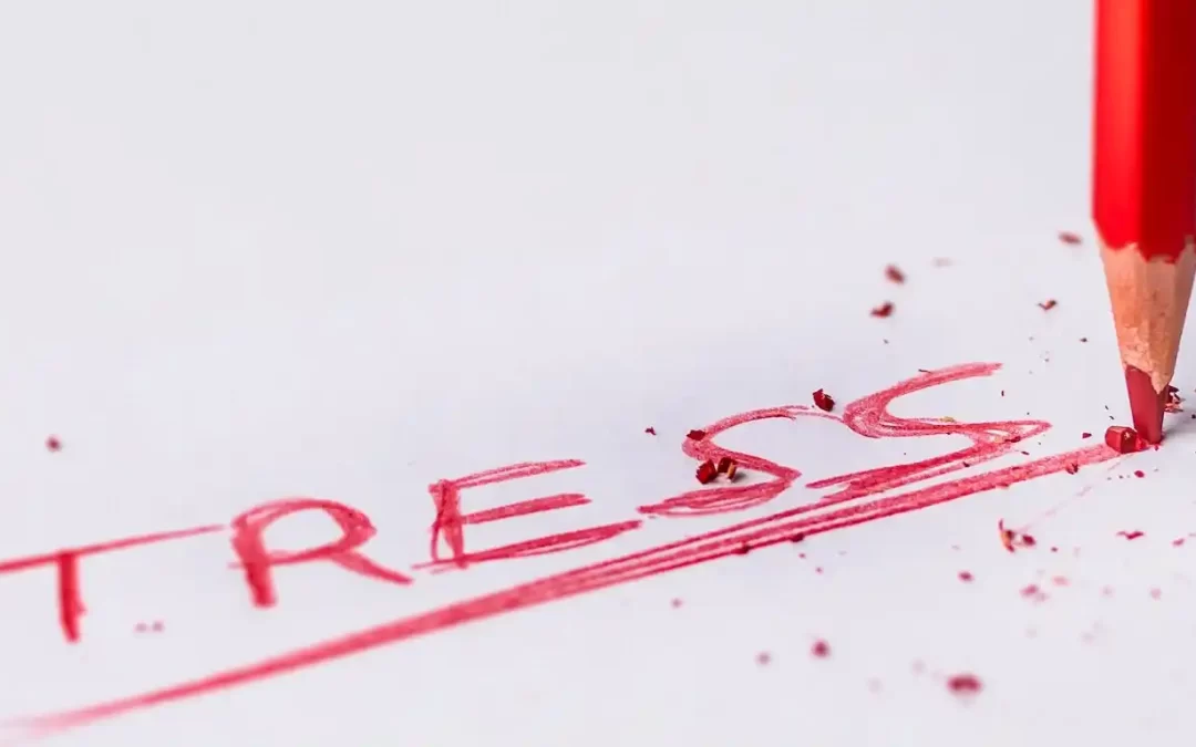 The word stress written in red, a red pencil scratching a bold line underneath the word